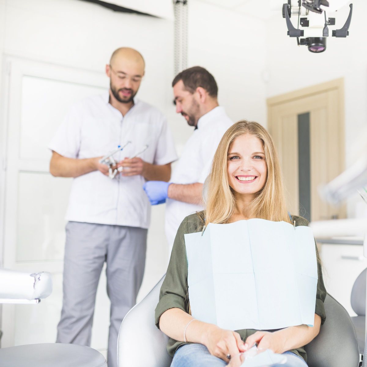 Smiling patient in the dental chair with her care team